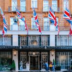 Facade of Claridge's Hotel in London with Union Jack flags displayed prominently